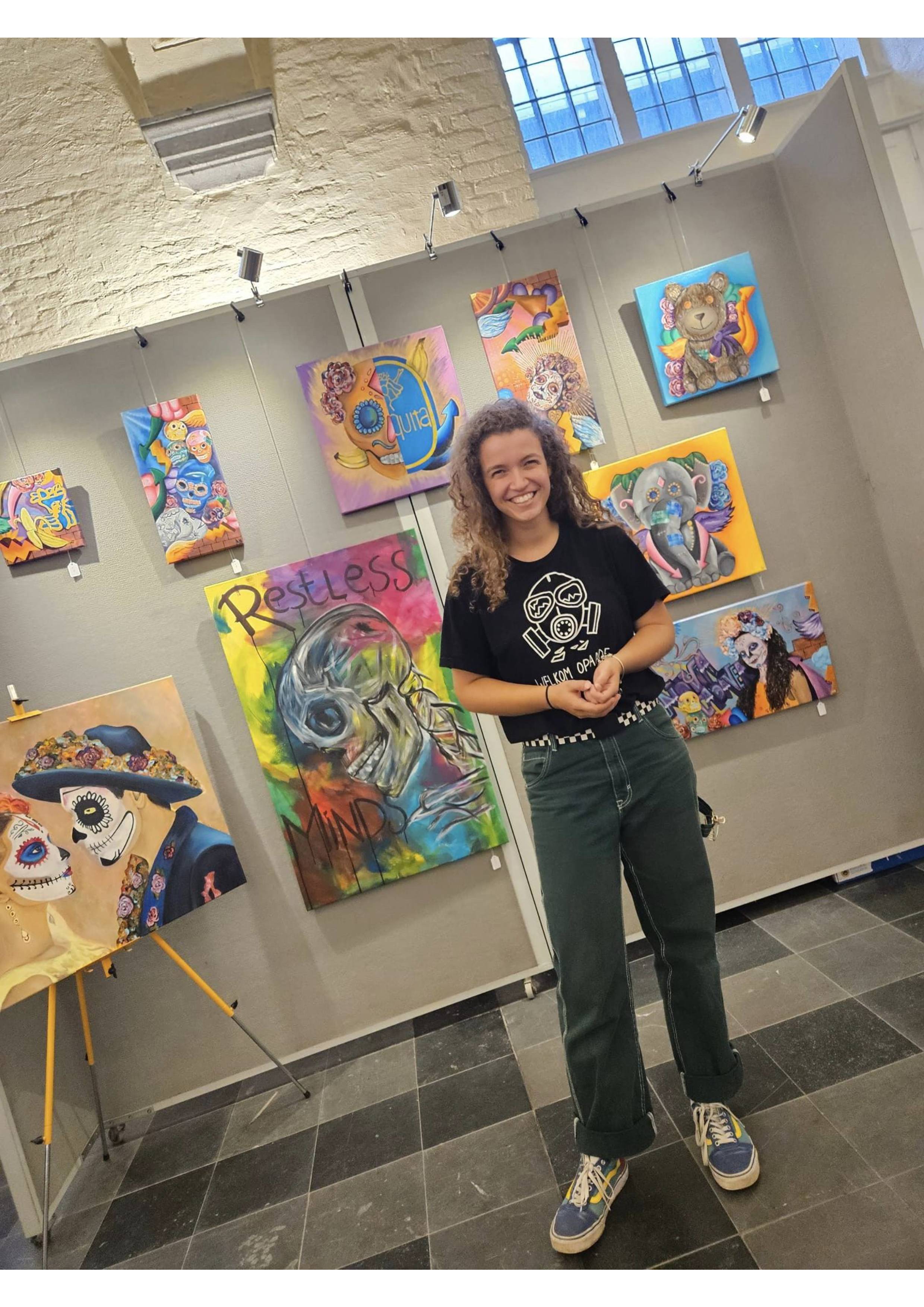 artist with paintings in background